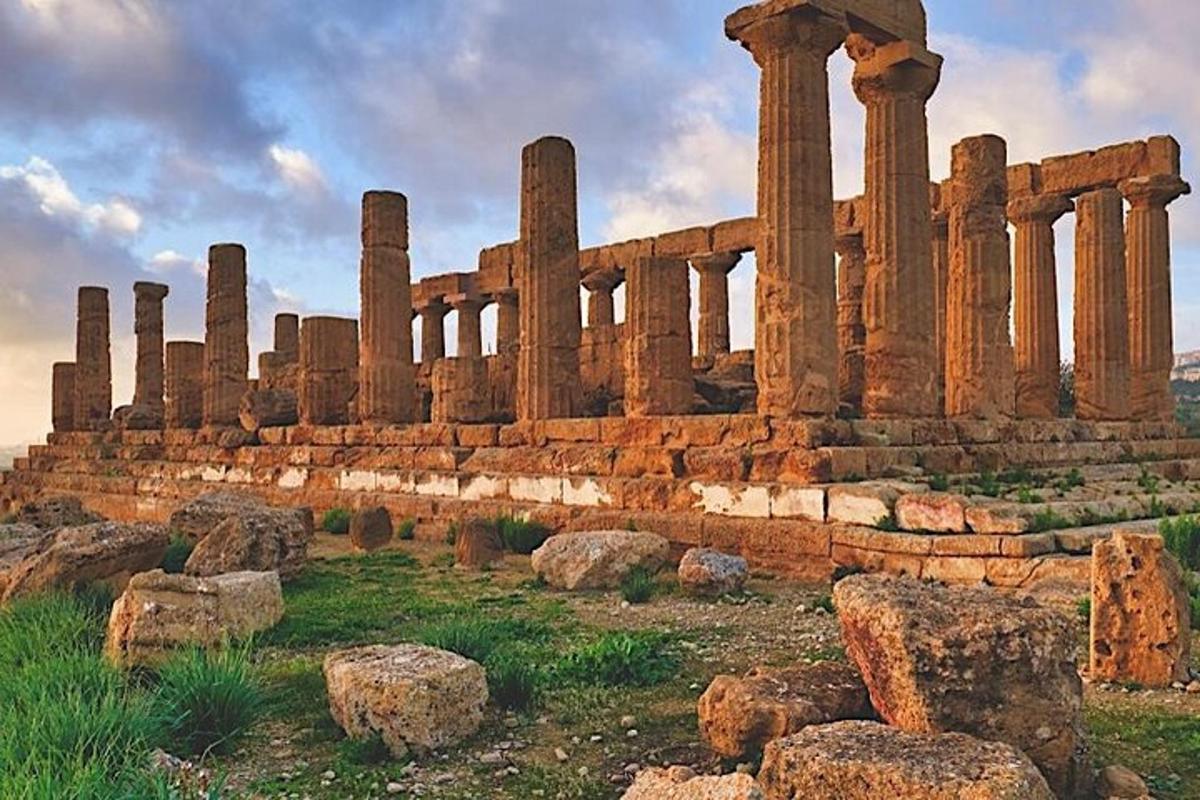 un antico edificio con colonne su un campo con rocce