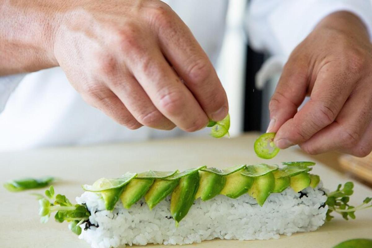 osoba drží kus sushi