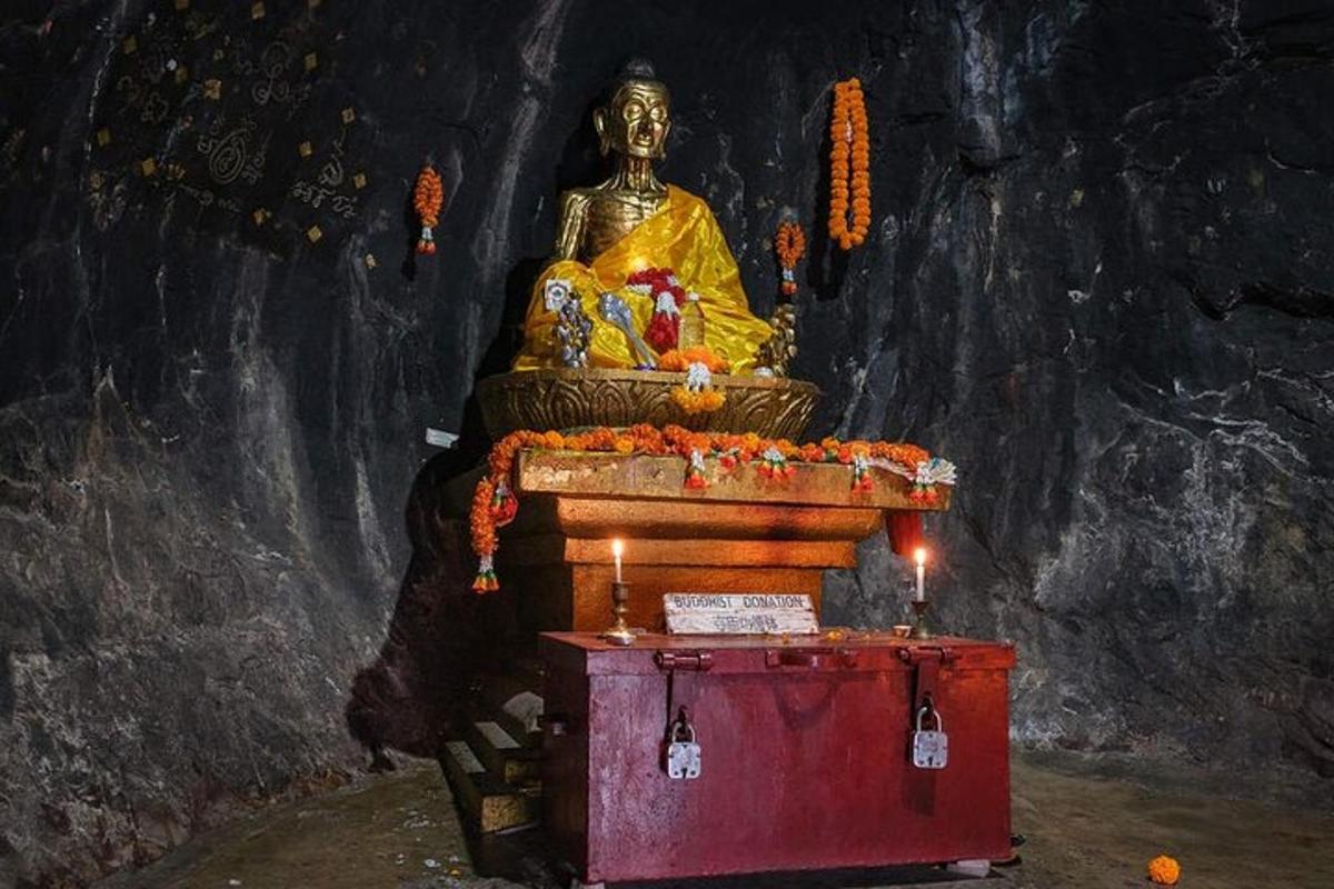 a large statue in a cave with a lit candle