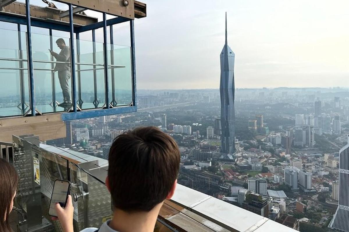 a man taking a picture of the shard from the observation deck of a building
