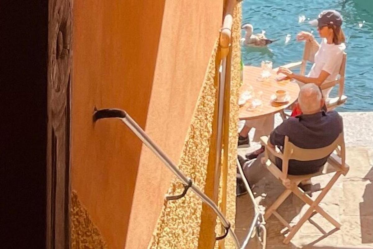 un gruppo di persone sedute a un tavolo vicino all'acqua