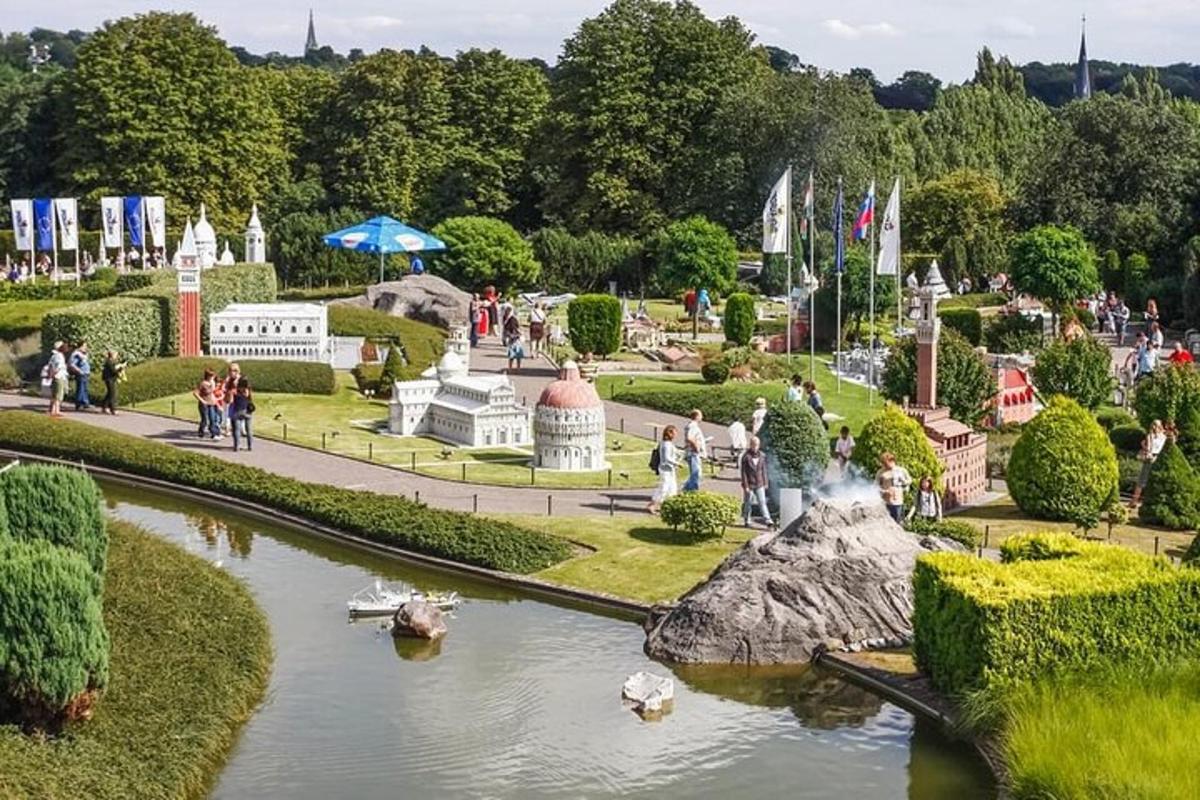 people walking around a garden with boats in the water