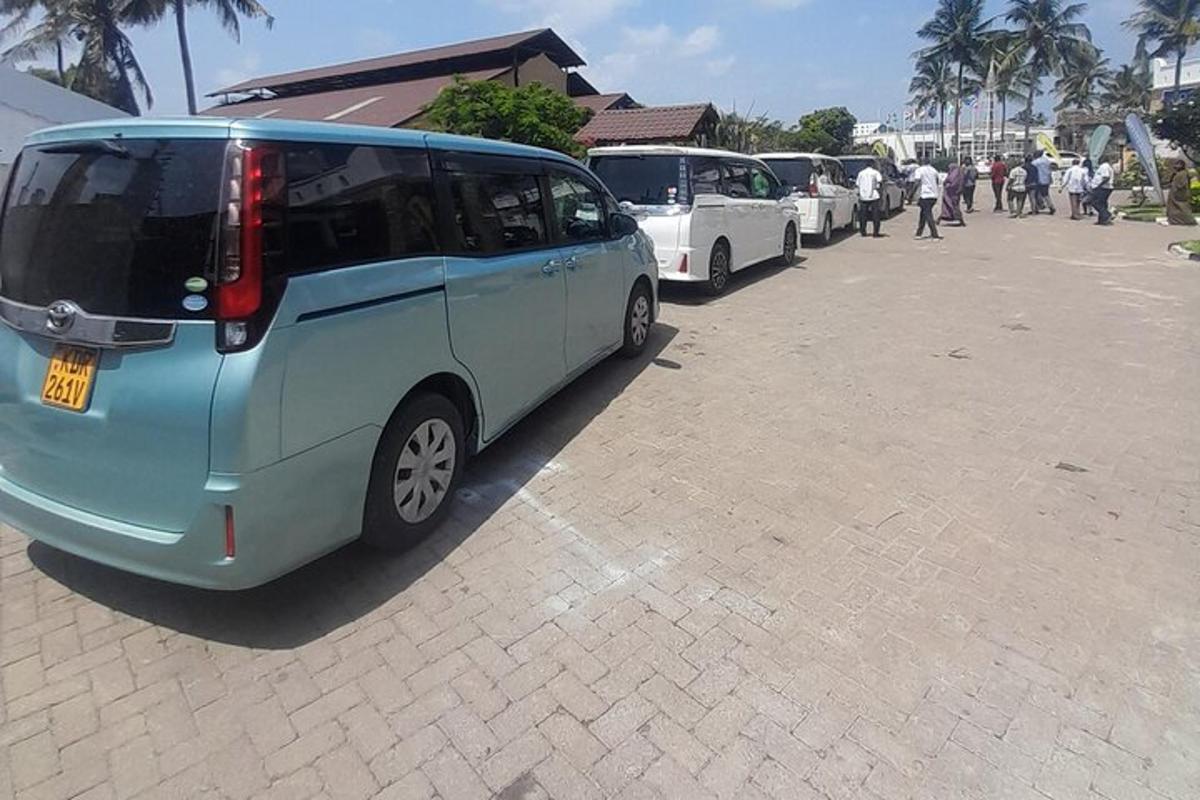 a blue van parked in a parking lot with other cars