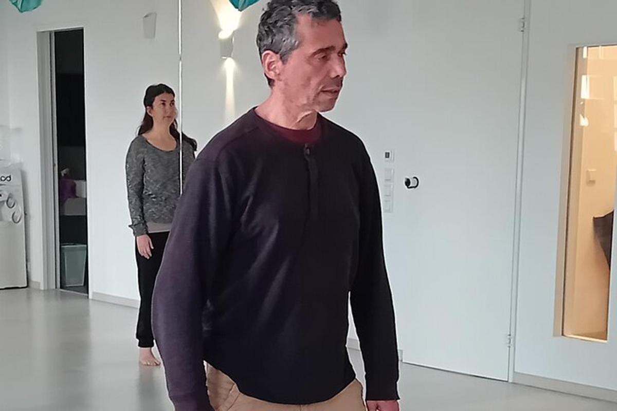 maður stendur í herbergi með konu á eftir sér