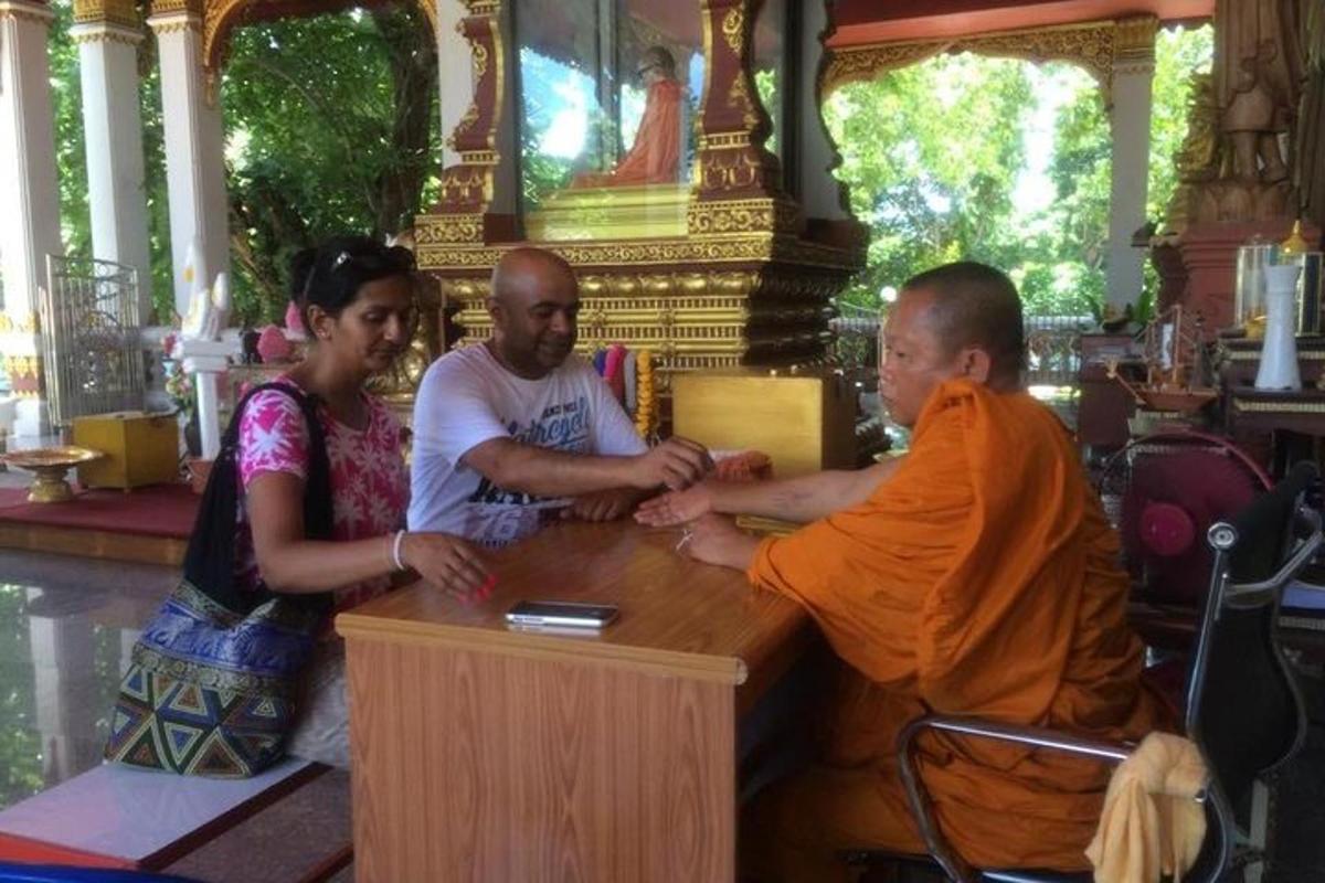 sekumpulan orang duduk mengelilingi meja dengan seorang sami