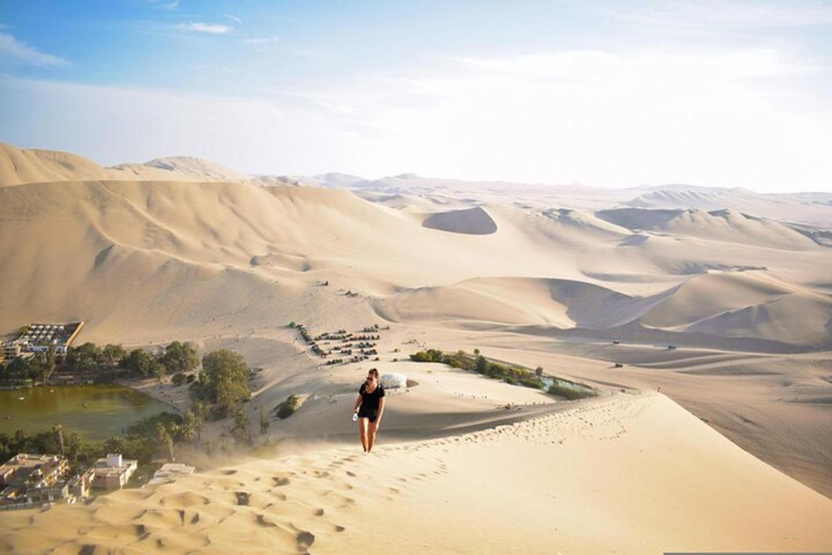 una mujer caminando sobre una duna de arena en el desierto