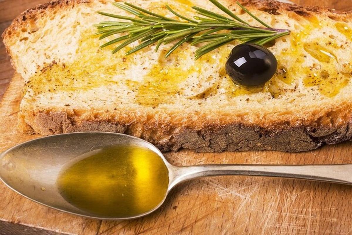 o lingură și o bucată de pâine cu o măslină pe ea