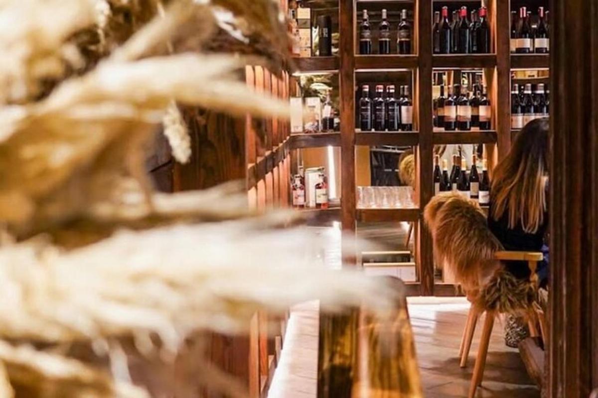 a woman sitting at a bar in a wine store