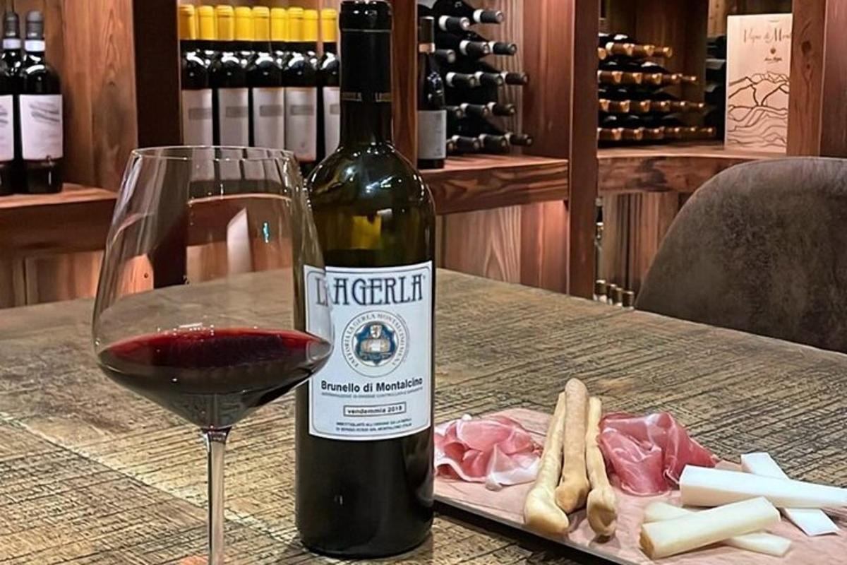 uma garrafa de vinho tinto ao lado de um copo