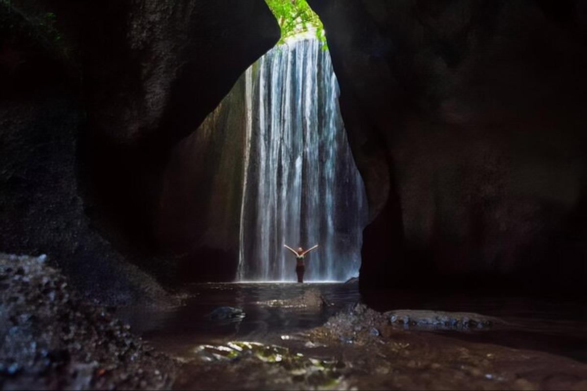 seseorang yang berdiri di hadapan air terjun