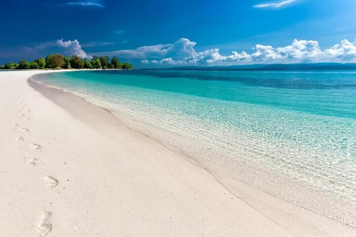 plaža s otiscima stopala u pijesku i oceanu