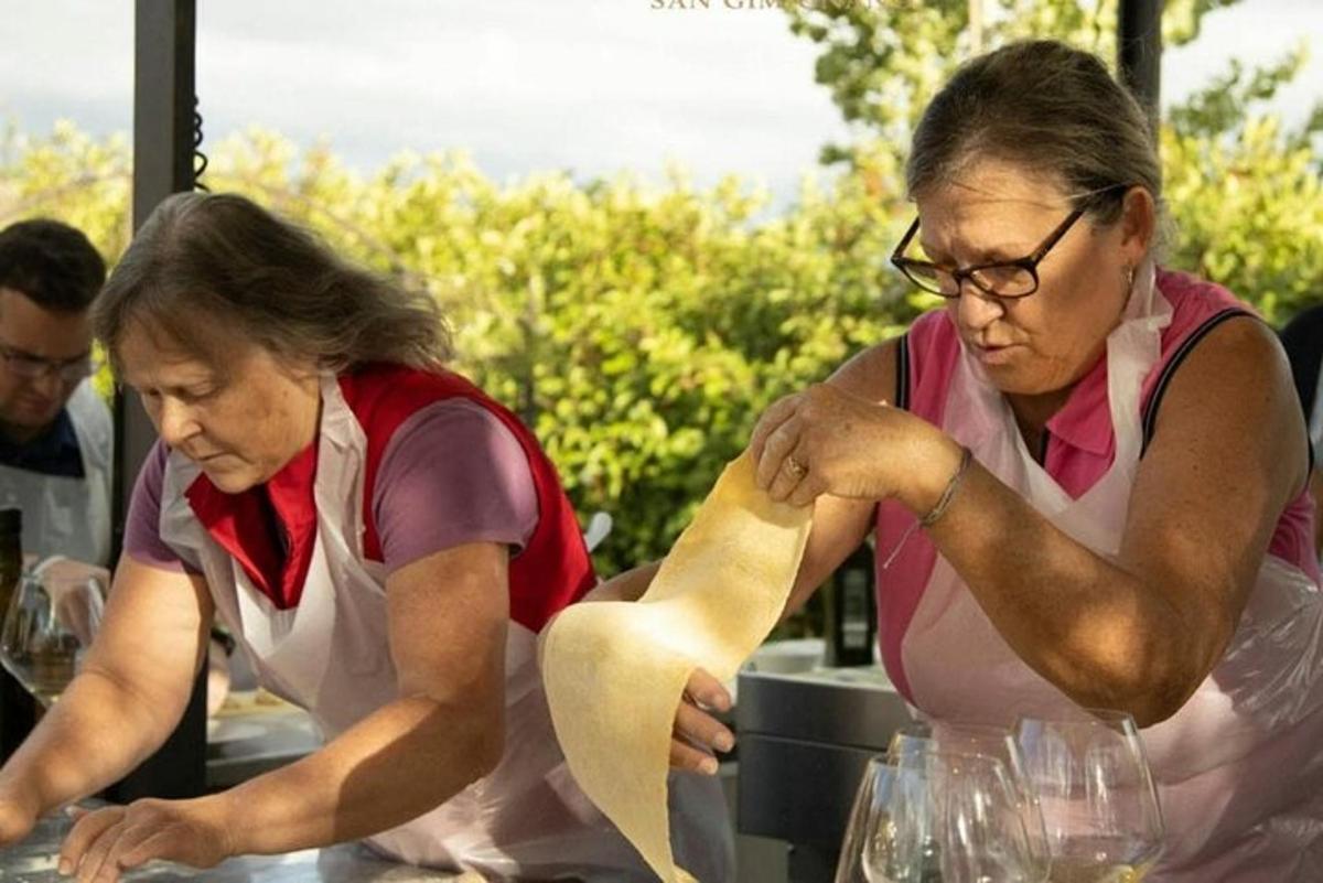 divas sievietes stāv pie galda, gatavo ēdienu
