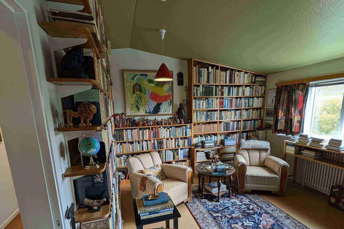 Una sala de estar llena de estanterías llenas de libros.