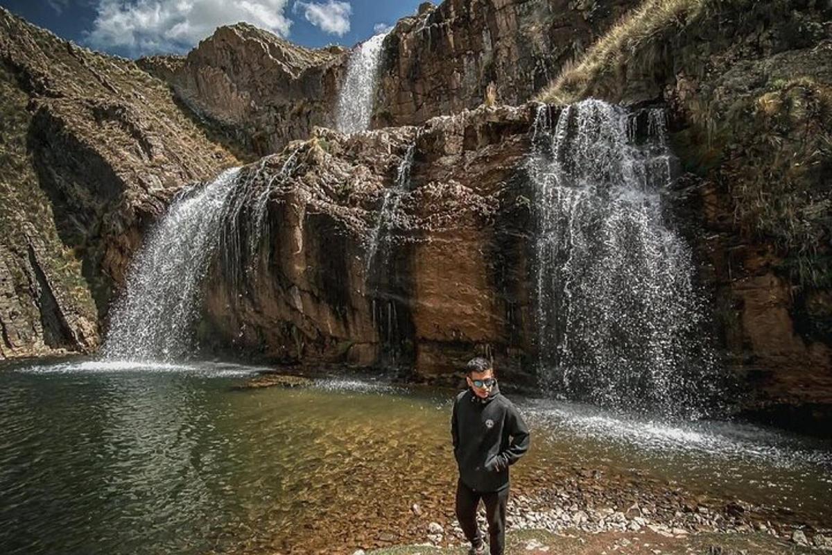 ein Mann steht vor einem Wasserfall