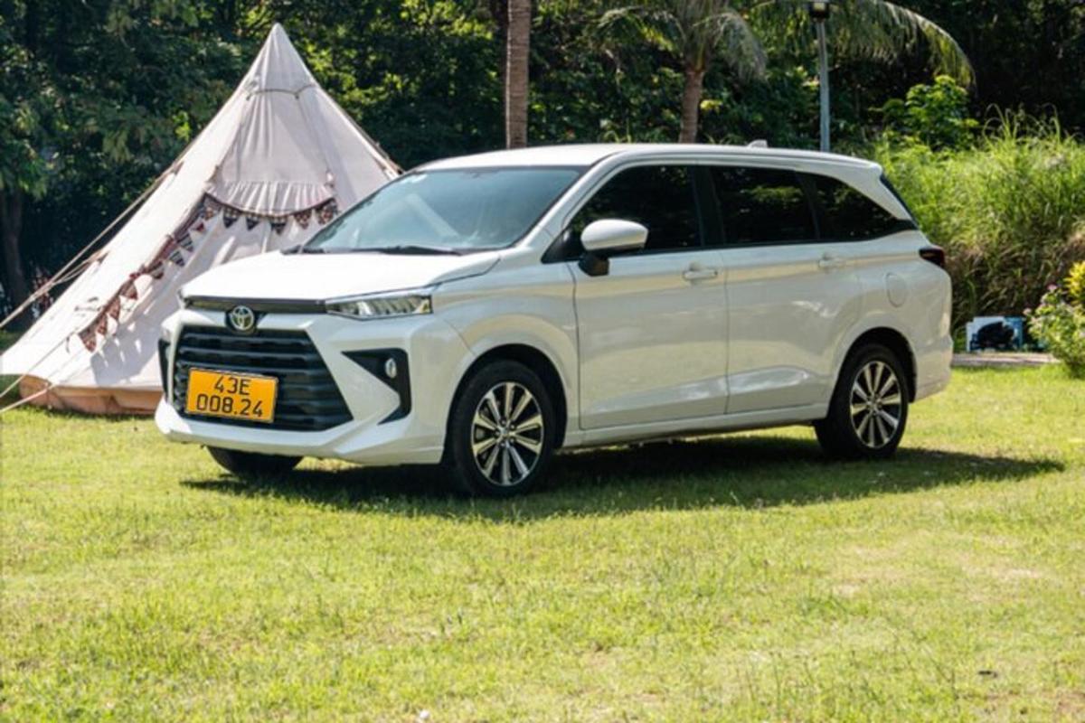รถ SUV สีขาวจอดอยู่ในทุ่งนาพร้อมเต็นท์