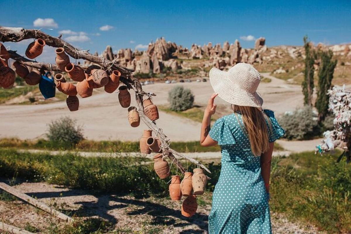 una donna con un vestito blu e un cappello che guarda il deserto