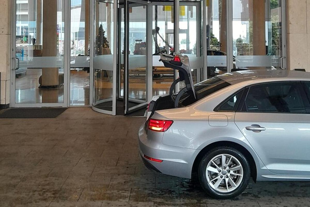 Un coche con una scooter aparcado en un edificio