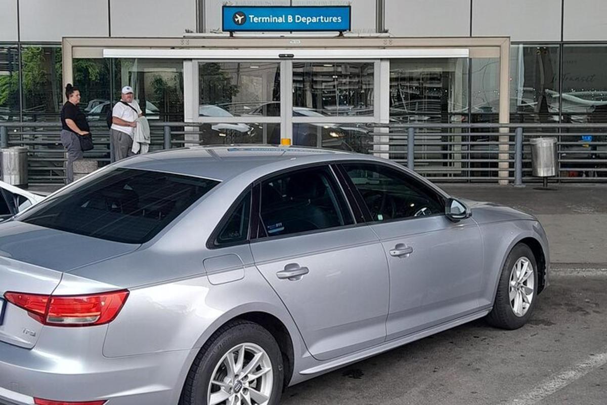 Un coche plateado aparcado delante de un edificio.