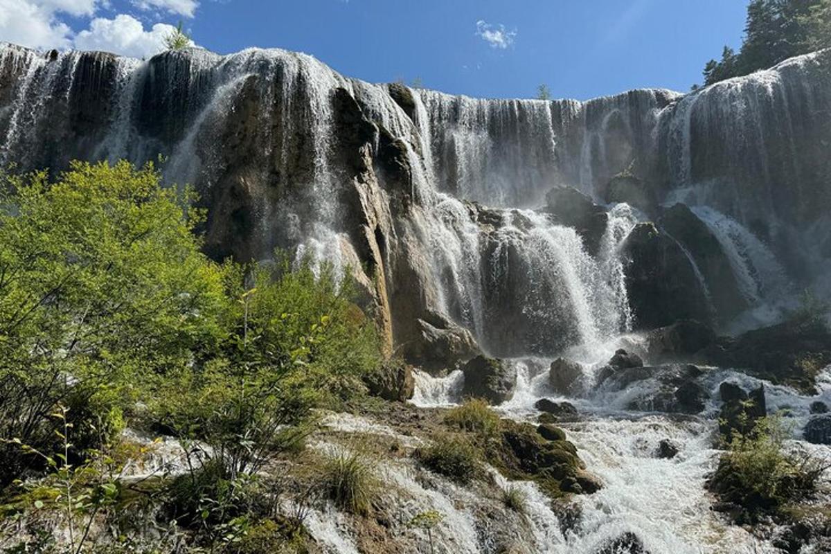 a large waterfall in the middle of a forest