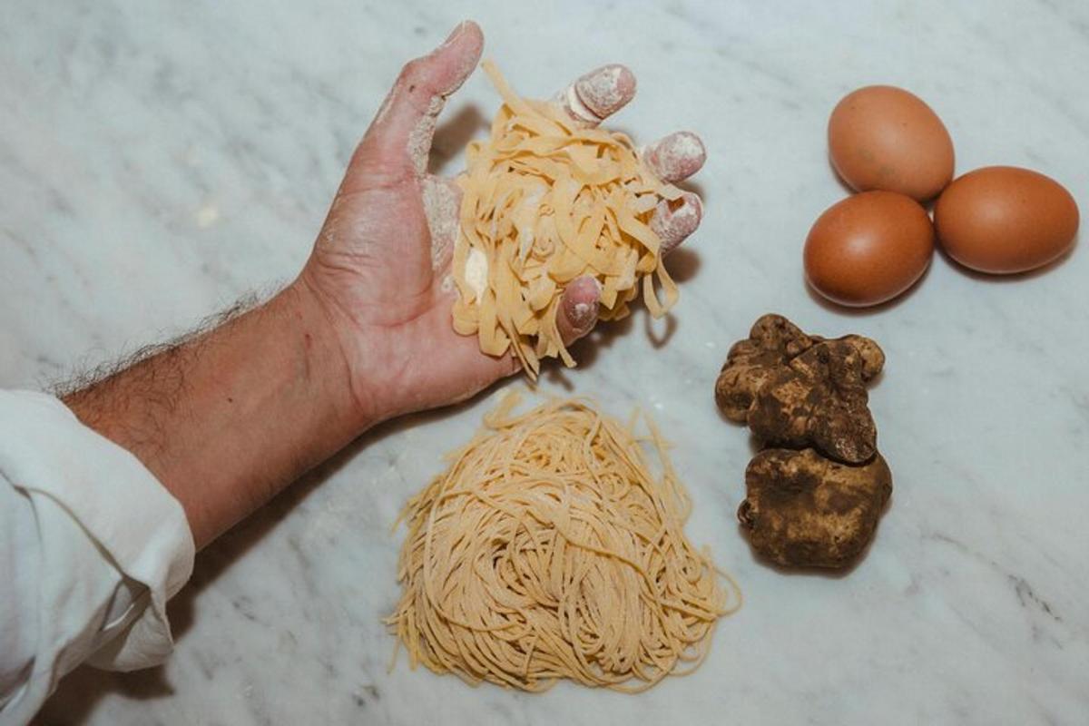 La mano de una persona sosteniendo un montón de fideos y huevos.
