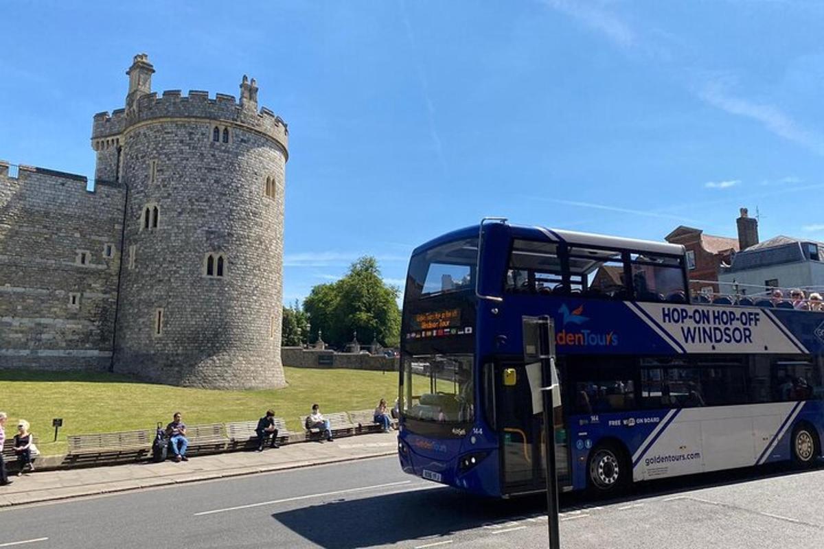 un autobus blu a due piani che passa davanti a un castello