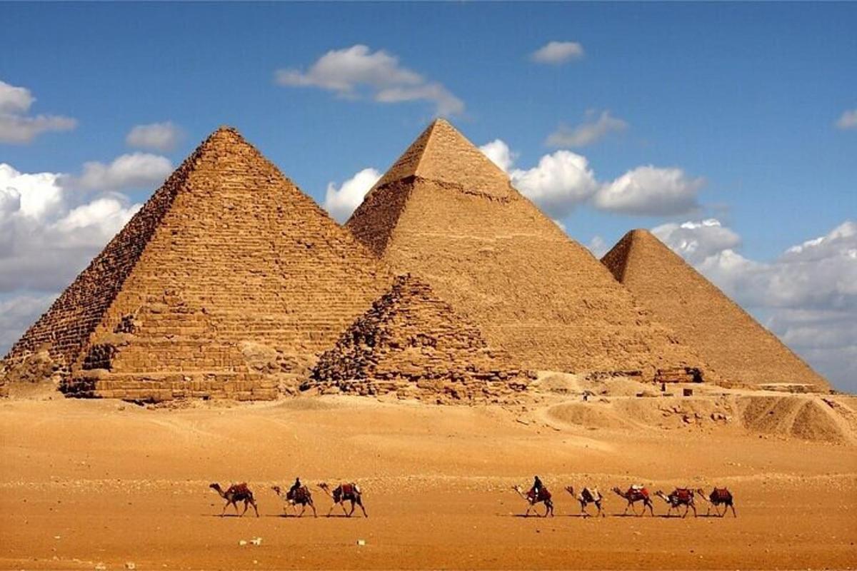 eine Gruppe von Menschen, die vor Pyramiden reiten