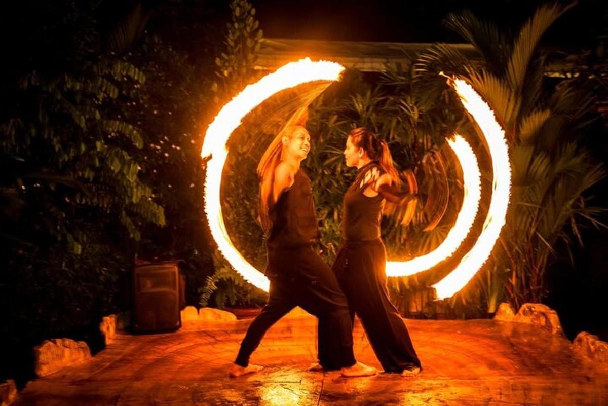 two women walking in front of a circle of fire