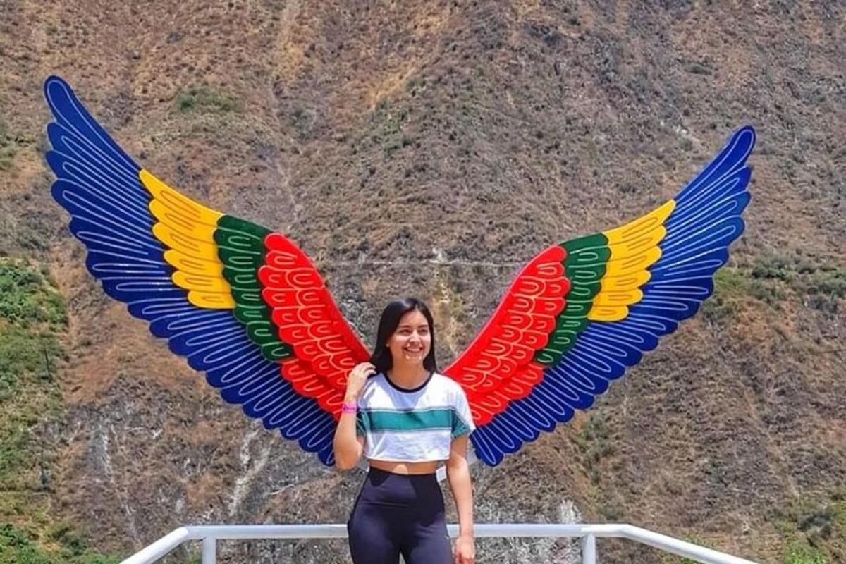 a woman standing in front of two large wings