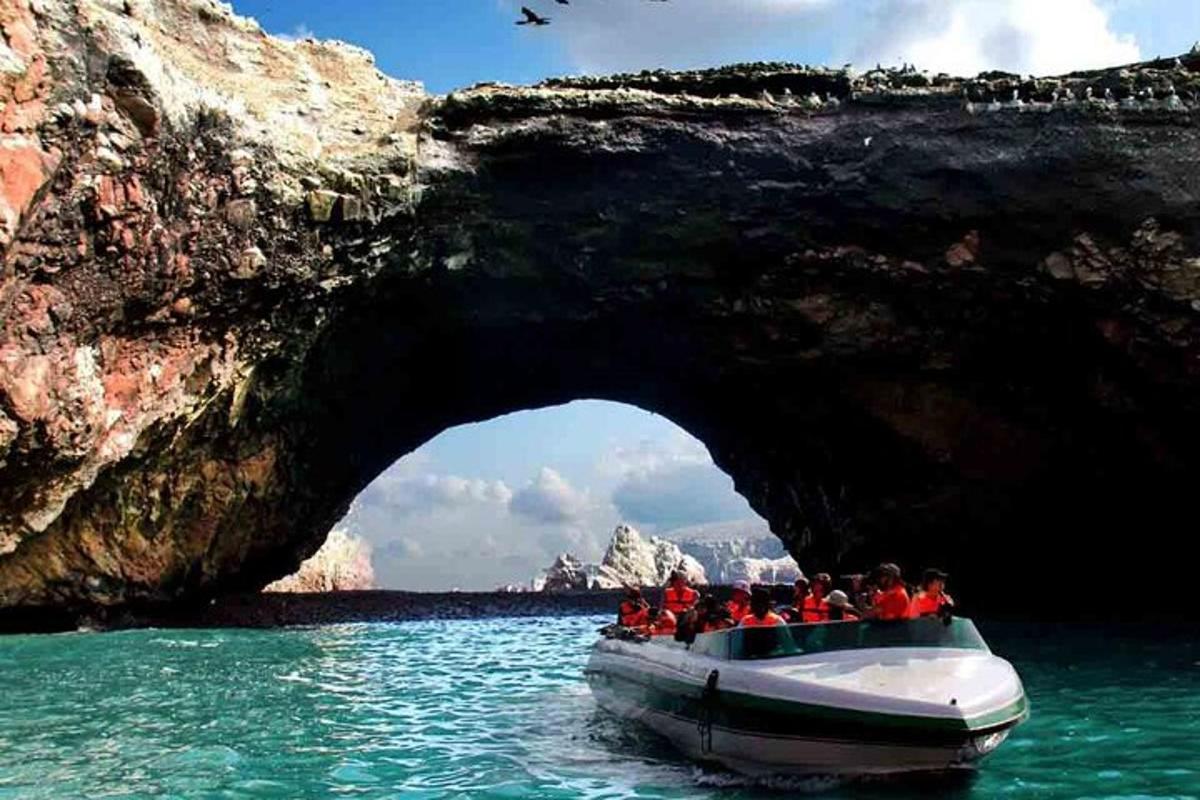 un gruppo di persone su una barca di fronte a una grotta