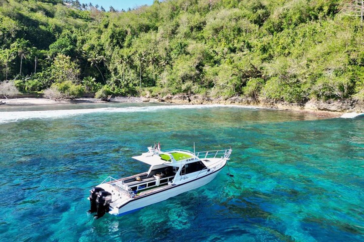 a boat floating in the water near a beach