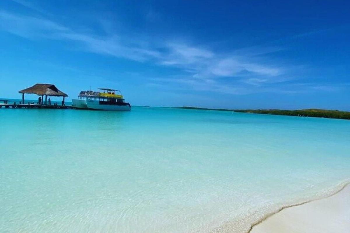 una grande barca in acqua vicino a una spiaggia