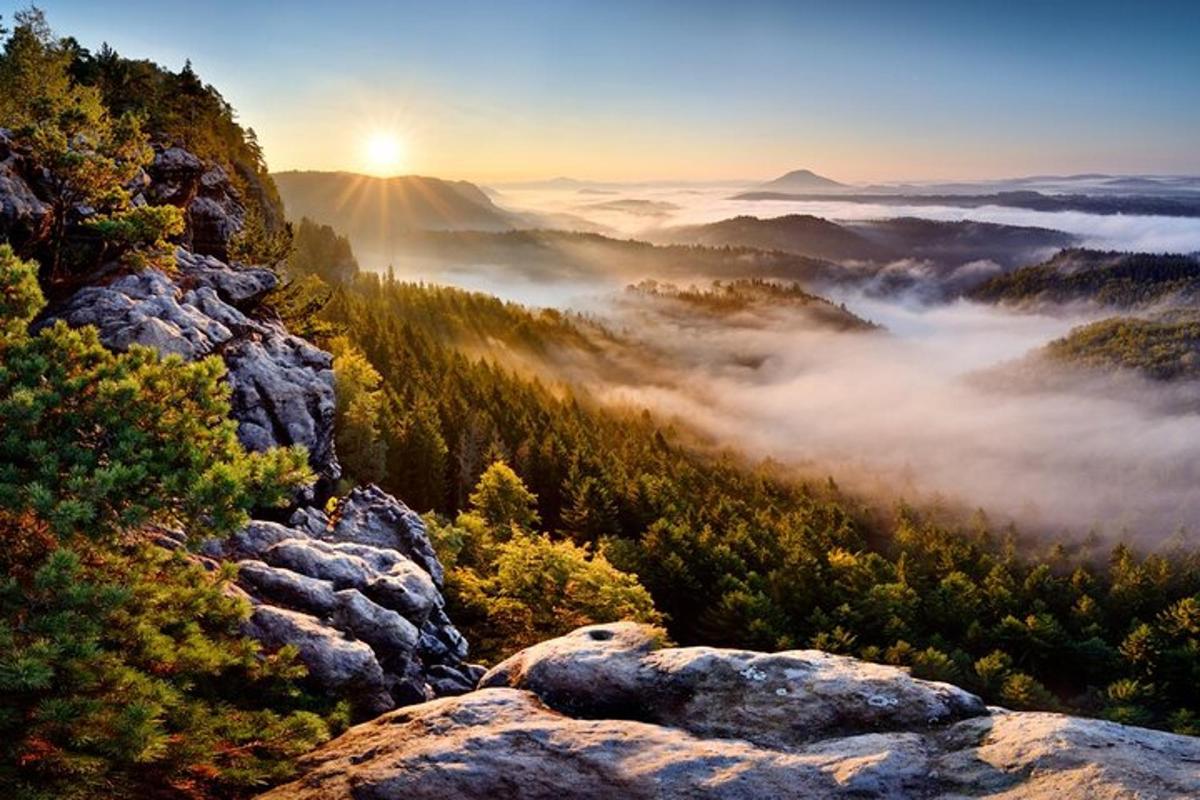 ein Blick auf ein nebliges Tal mit der Sonne im Hintergrund