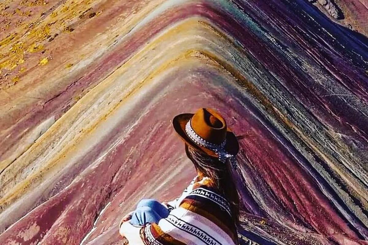 그림 앞에 앉아 있는 모자를 쓴 사람