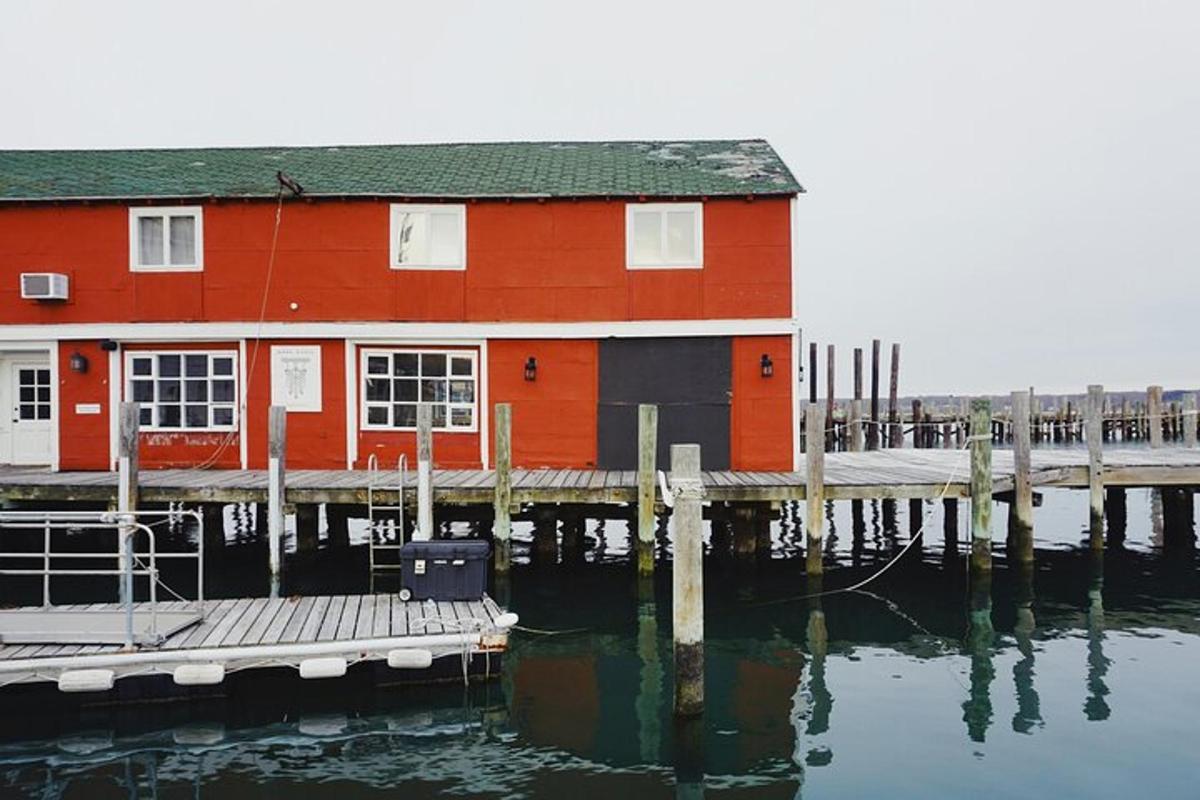 et rødt hus ved vannet ved siden av en brygge