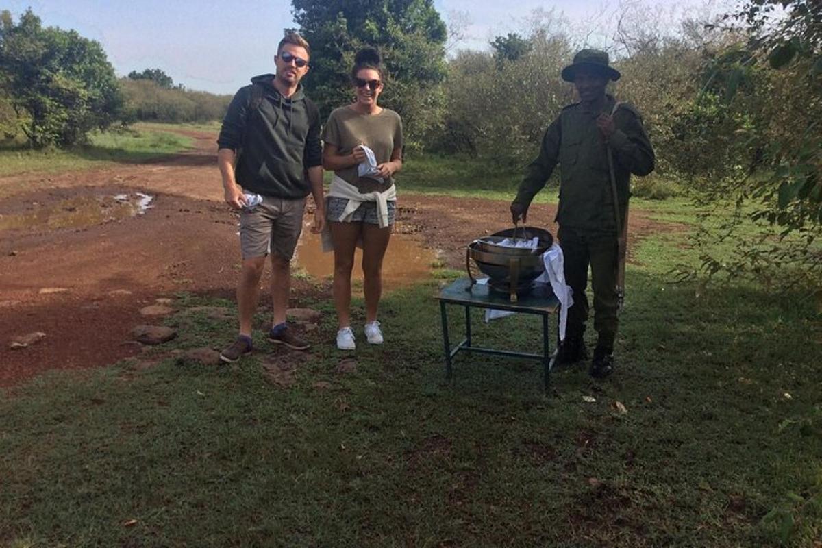 Két férfi és egy nő áll egy grill mellett