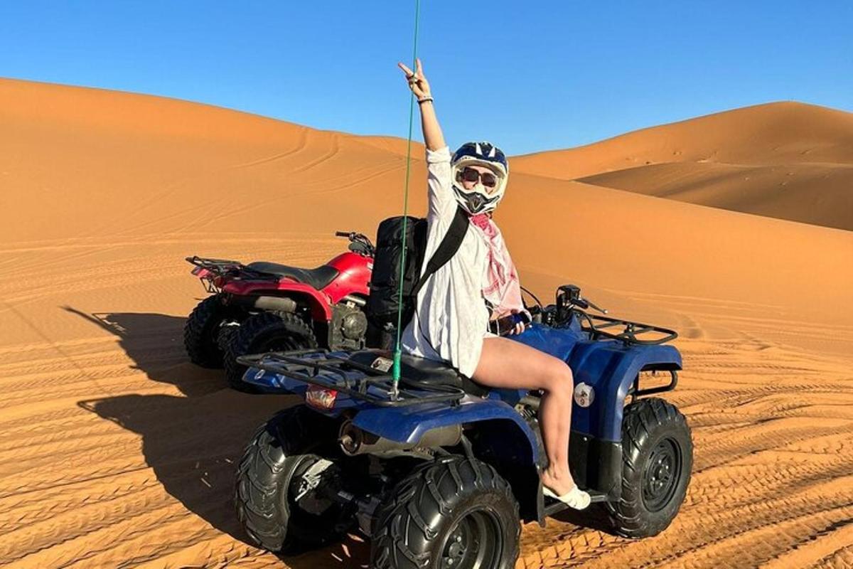 una persona che guida un quad nel deserto
