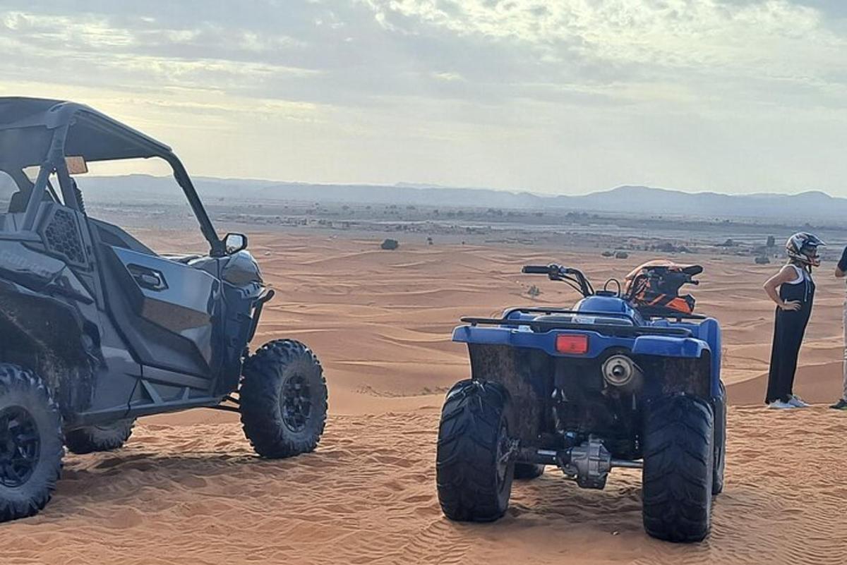 una persona in piedi accanto a un veicolo nel deserto