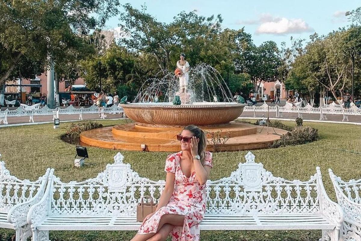 una donna seduta su una panchina bianca davanti a una fontana