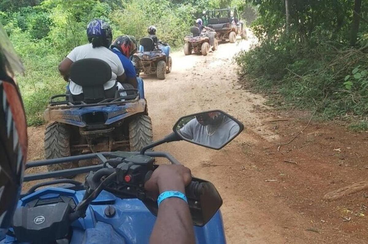 a group of people riding on atvs on a dirt road