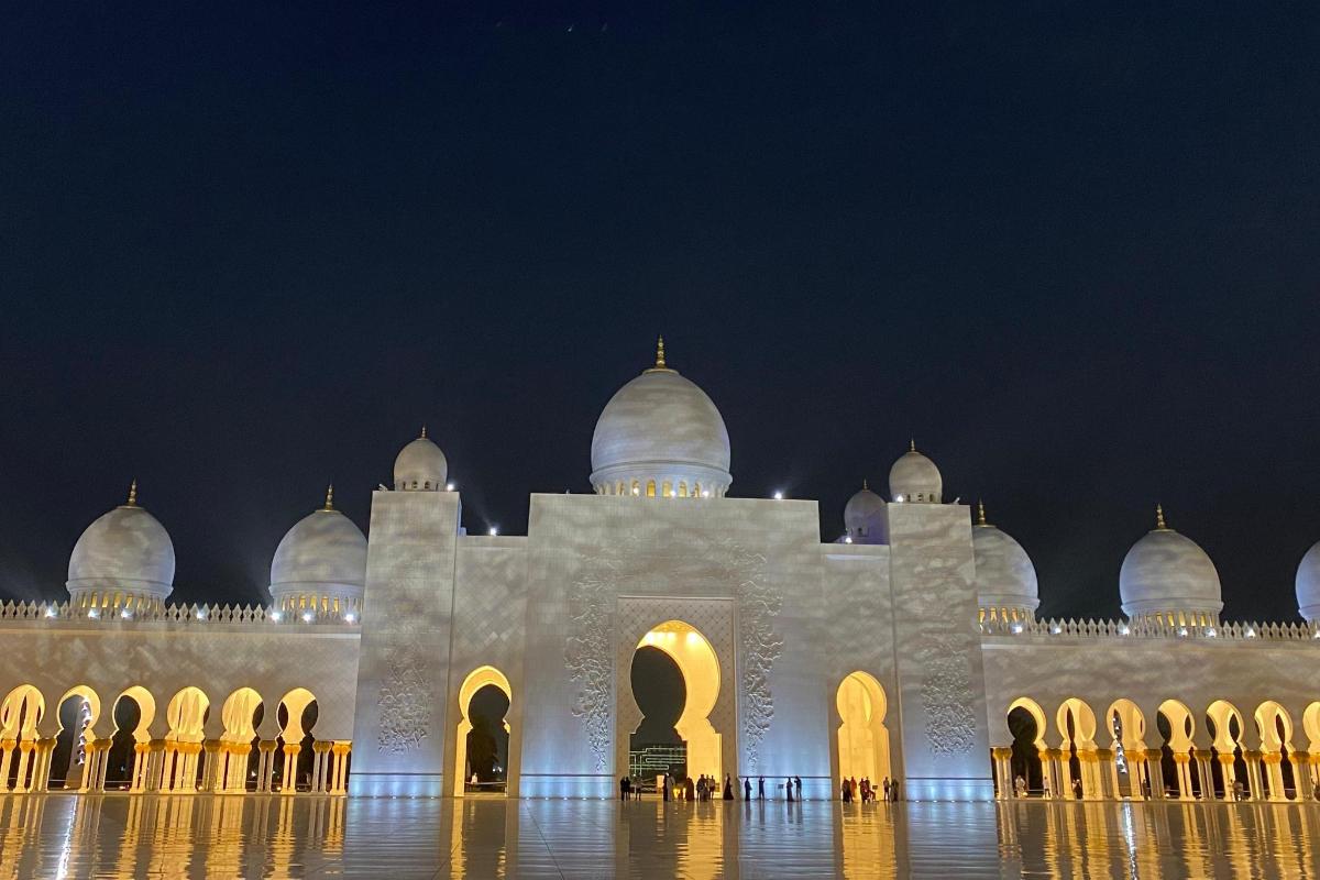 Un gran edificio blanco con cúpulas por la noche.