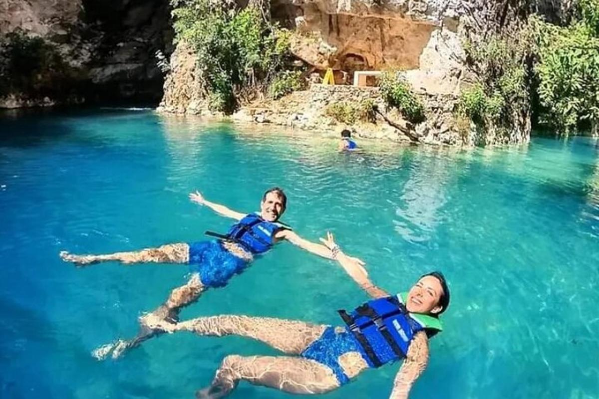 due persone sdraiate nell'acqua di un lago blu