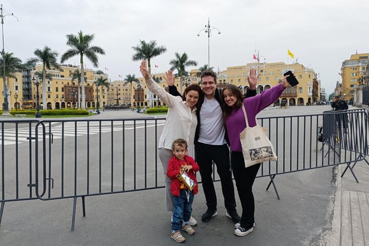 Una familia posando para una foto frente a una valla.