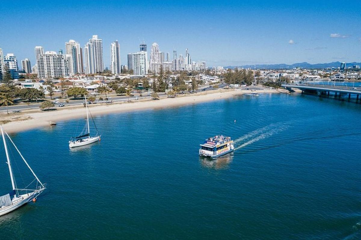 two boats in the water near a beach with a city