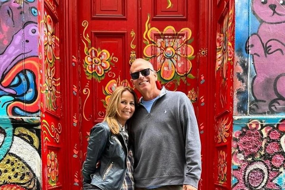 a man and a woman standing in front of a red door