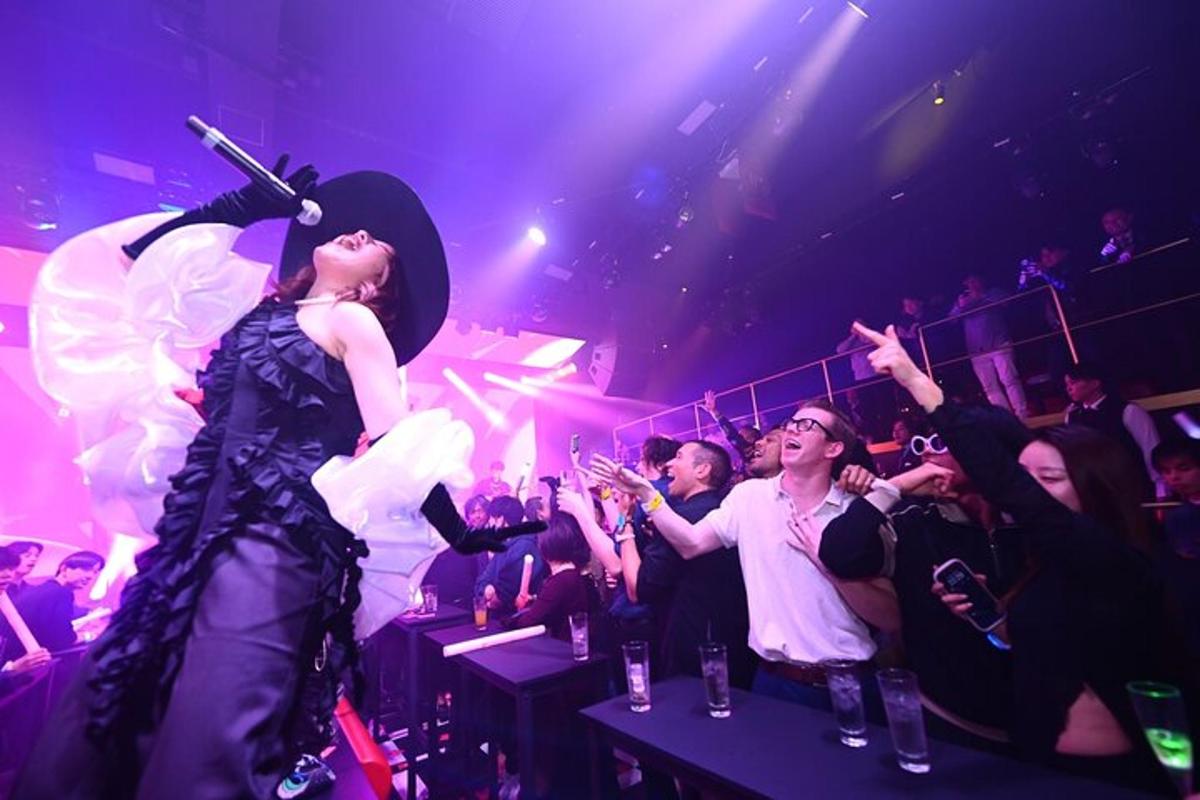 a woman standing in front of a crowd at a party