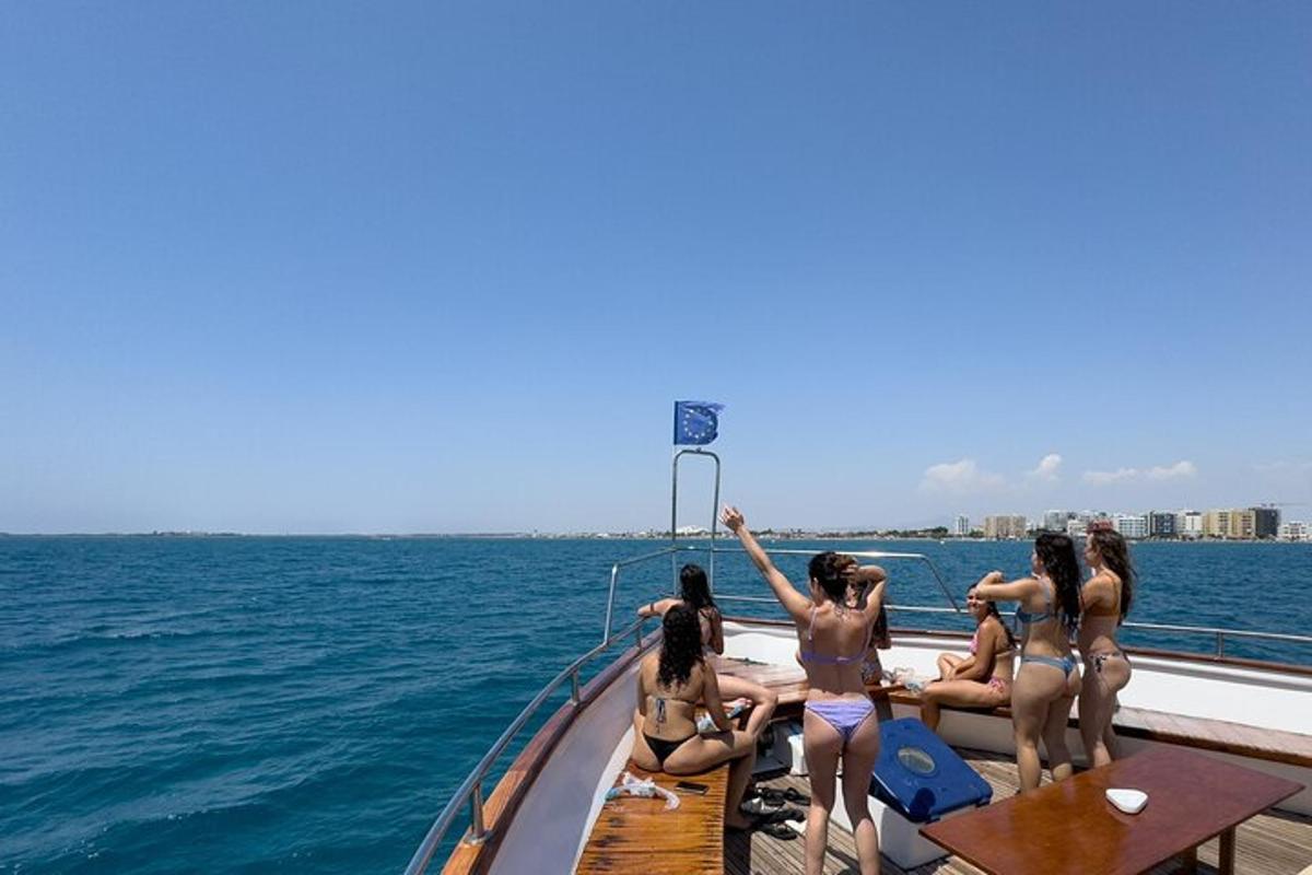a group of girls sitting on a boat in the water