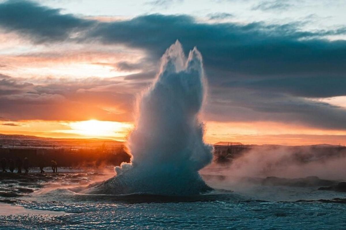 un geyser nell'acqua con un tramonto sullo sfondo