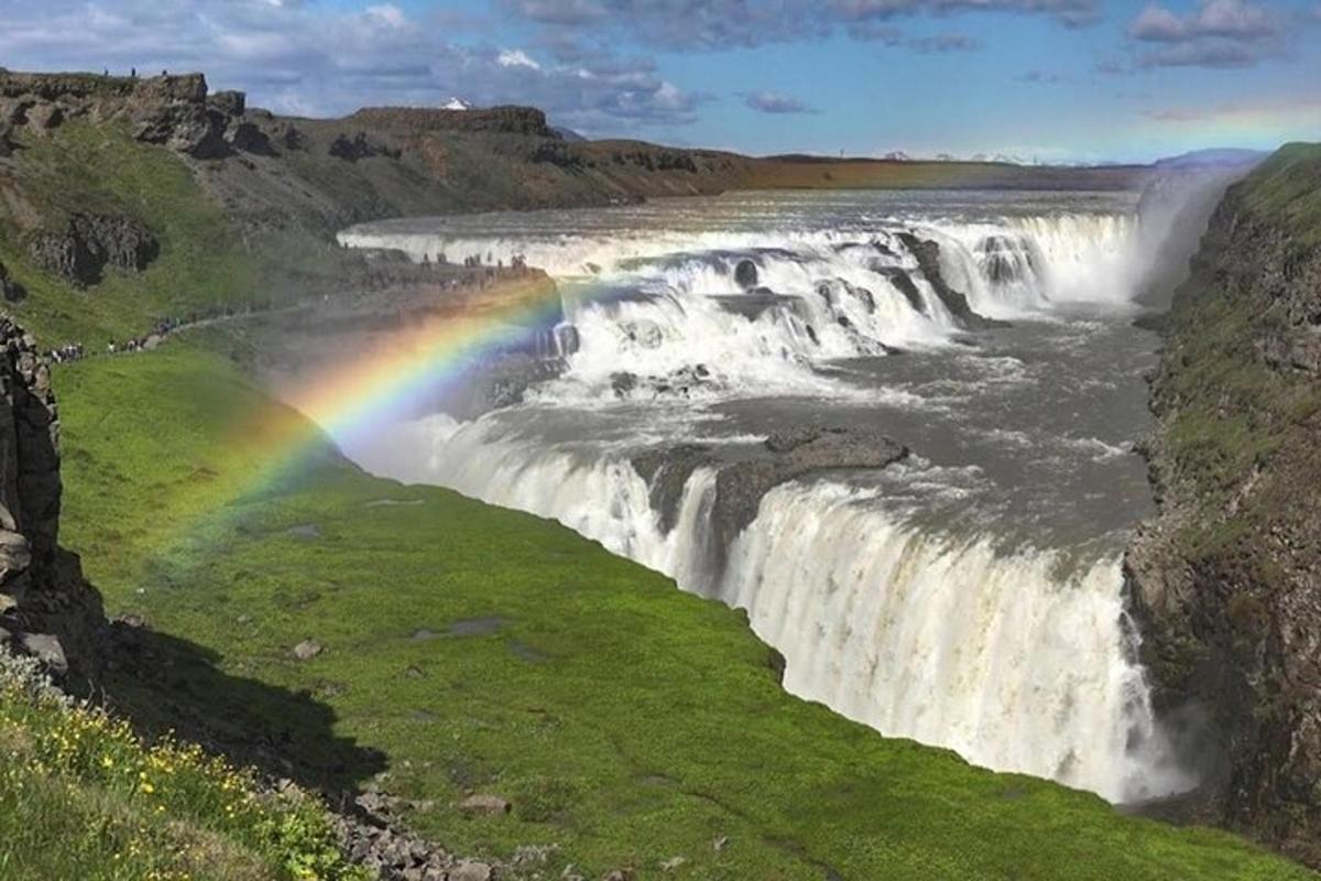 um arco-íris em frente a uma cachoeira