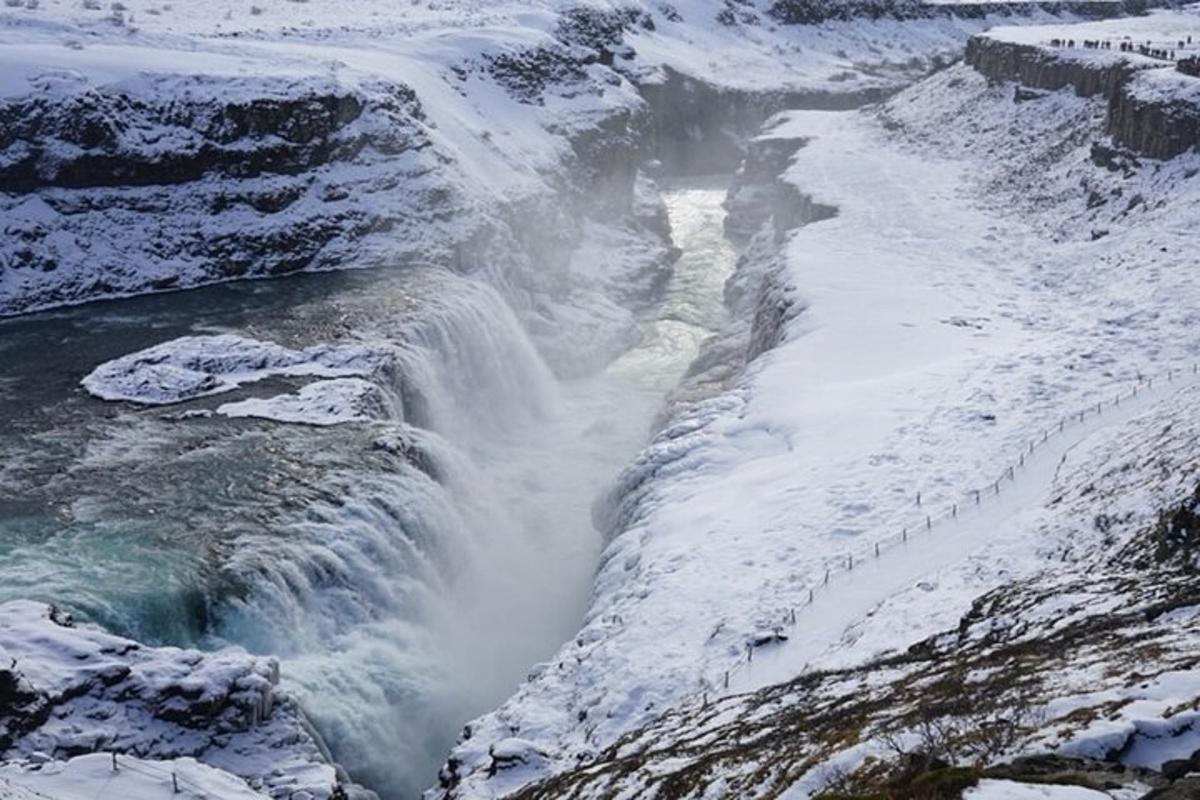 una cascata con la neve sul fianco di una montagna