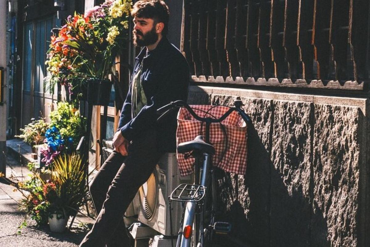 egy férfi ül egy falon egy bicikli mellett